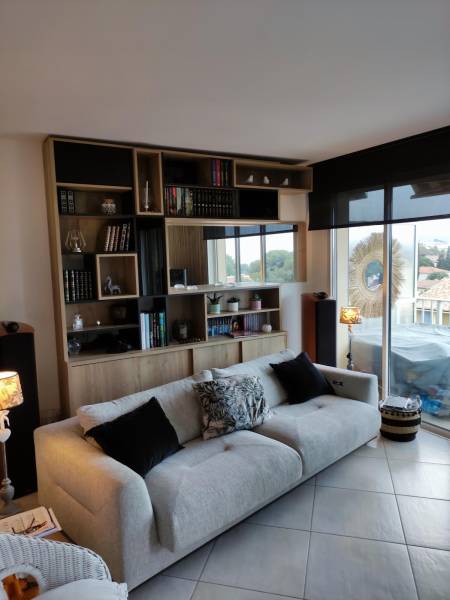 Rangements sur mesure avec niches décoratives dans un salon à Bandol.